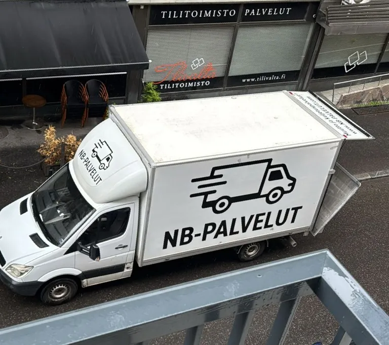 NB-Palveluiden kuorma-auto yrityksen logolla kadulla lastauskeikalla