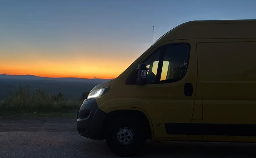 NB-Palvelut's yellow moving van at sunset